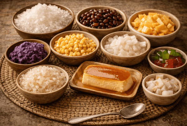 traditional halo-halo ingredients including ube halaya, leche flan, sweet corn, coconut, nata de coco, shaved ice and fruit prepared for a Filipino halo-halo dessert recipe