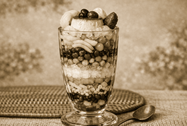 Traditional Filipino Halo-Halo dessert showing colorful layers of shaved ice, sweet beans, fruit, and ice cream representing the origins of Halo-Halo